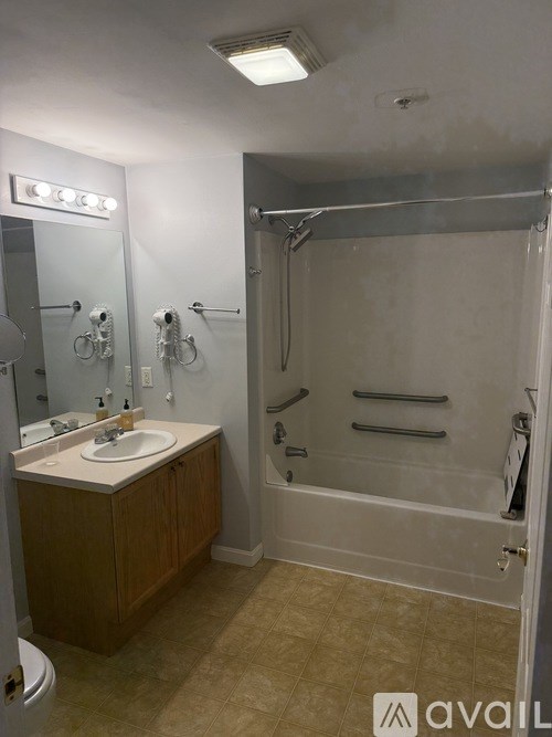 A bathroom with a sink, mirror, and shower.