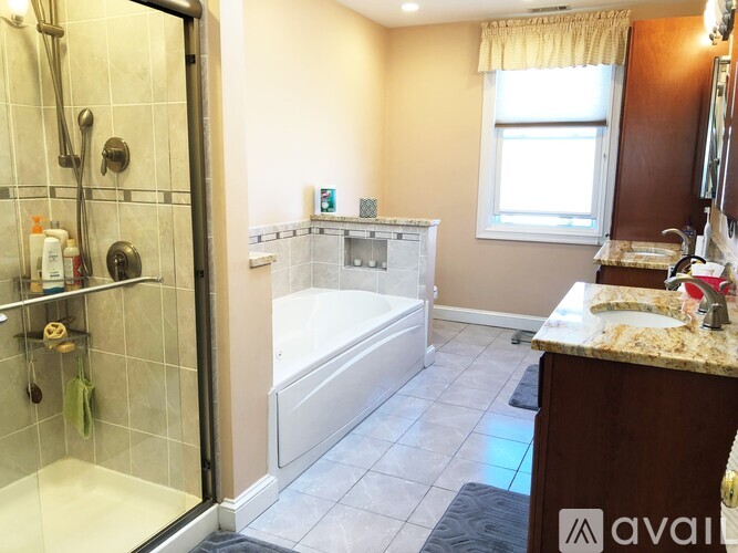 A bathroom with a walk-in shower, a bathtub, and a sink.