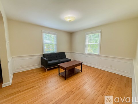 A living room with a black couch and a wooden coffee table.