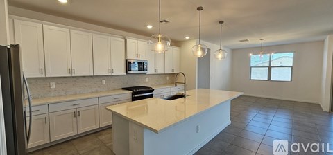 A kitchen with white cabinets and a large island.