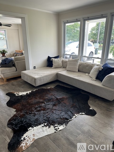 A living room with a cowhide rug in the center.