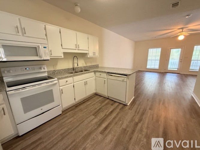 A kitchen with granite countertops and white cabinets.