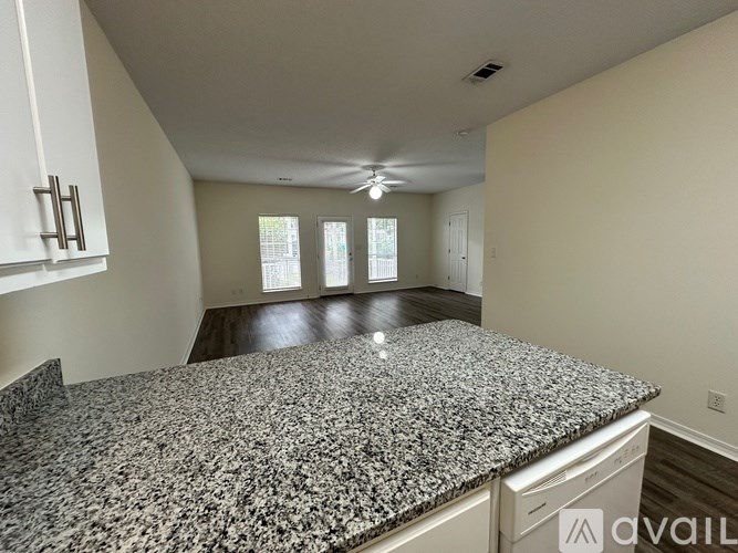 A kitchen with granite countertops and white cabinets.