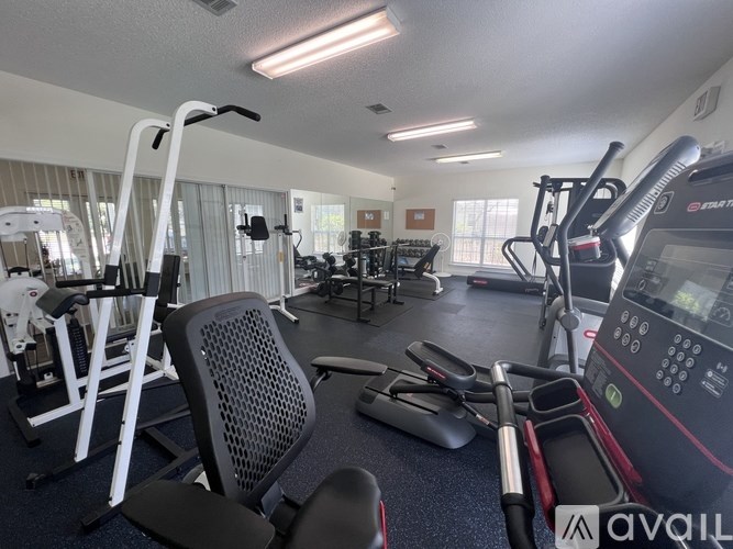 A gym with a variety of equipment including treadmills, weights, and exercise machines.