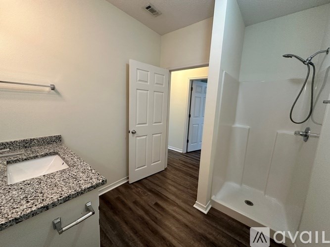 A bathroom with a marble countertop and a walk-in shower.