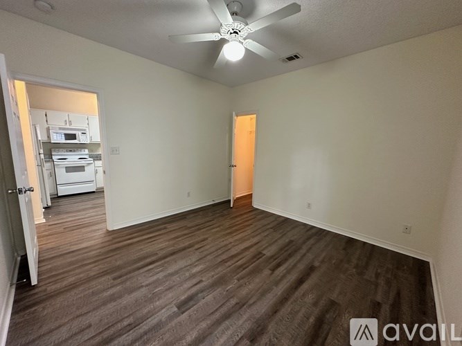 A room with a ceiling fan and wooden flooring.