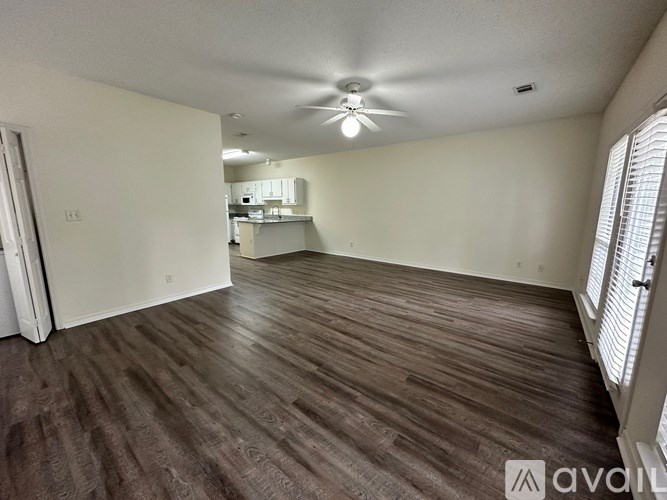 A room with wooden flooring and a ceiling fan.