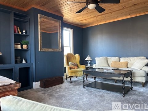 A living room with a yellow chair and a black coffee table.