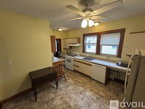 A kitchen with a table and a refrigerator.