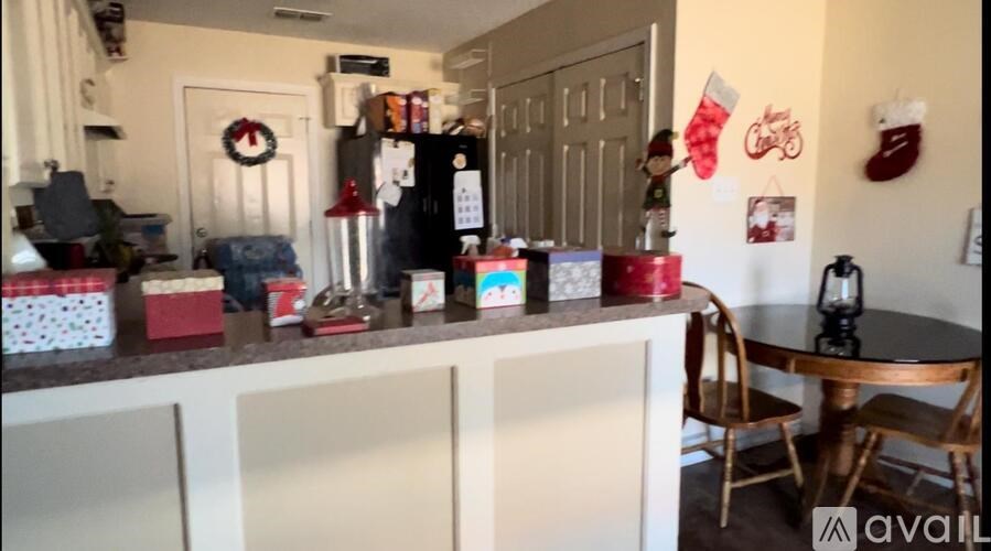 A kitchen with a table and chairs and a fridge decorated for Christmas.