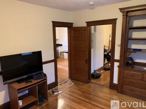 A living room with a television and a doorway leading to another room.