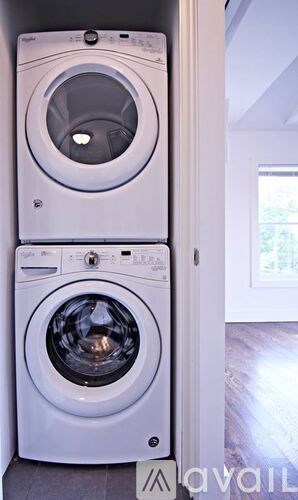 A white front loading washing machine with a top loading dryer.