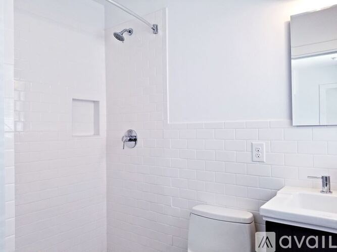 A white bathroom with a toilet, sink, and mirror.
