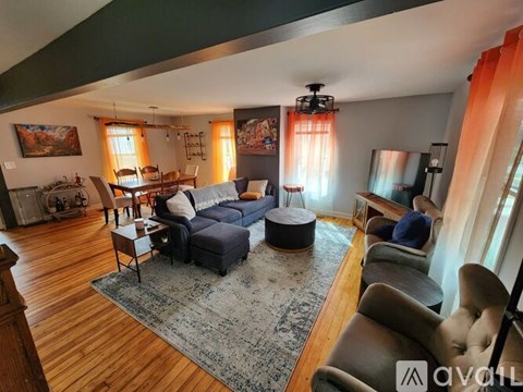 A living room with a blue sofa and a rug.