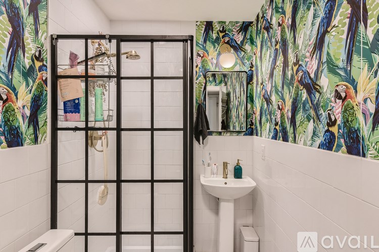 A bathroom with a white sink and a shower with a glass door.