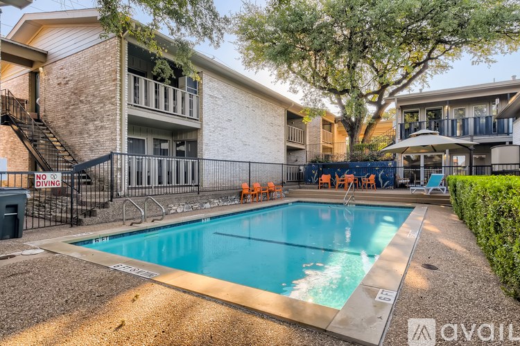 A pool surrounded by a black fence with a sign that says "NO DIVING".