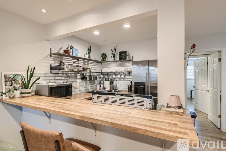 A kitchen with a wooden counter and a brown chair.