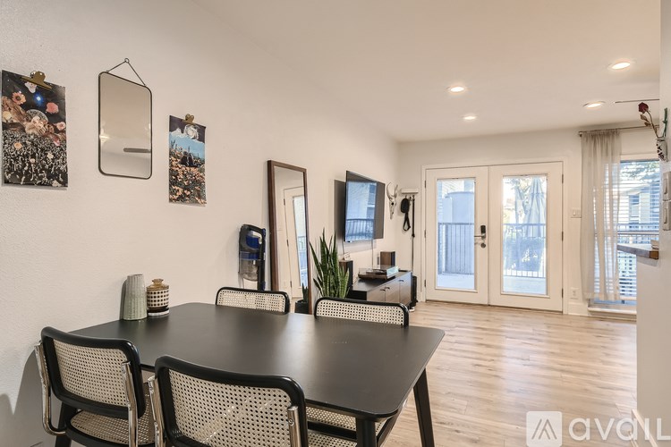 A dining room with a black table and chairs.