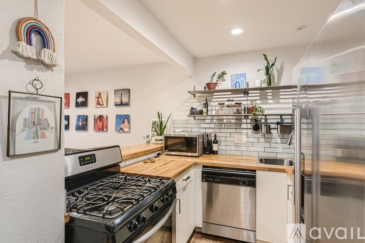 A kitchen with a stove top oven and a fridge.
