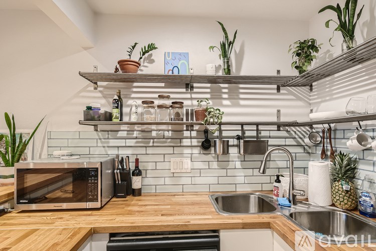 A kitchen with a wooden countertop and a stainless steel sink.