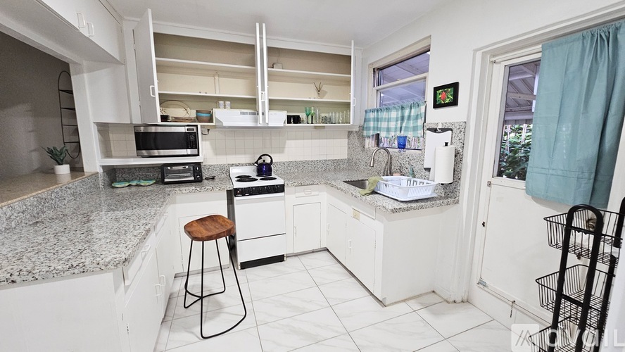 A kitchen with white cabinets and a granite countertop.