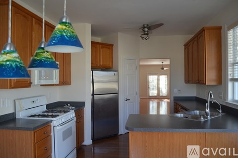 A kitchen with wooden cabinets and a stainless steel refrigerator.