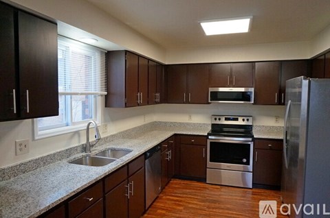 A kitchen with dark wood cabinets and stainless steel appliances.