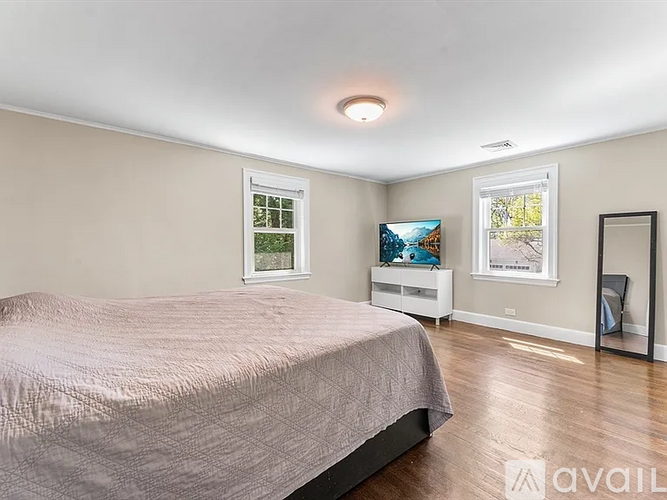 A bedroom with a large bed and a painting on the wall.