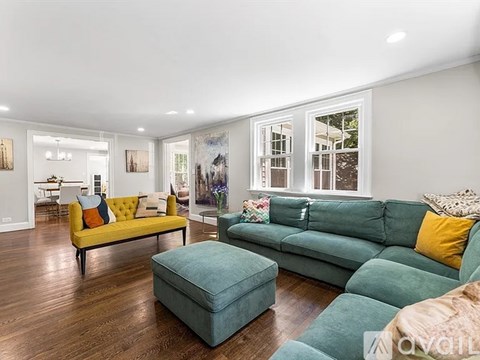 A living room with a green couch and a yellow couch.