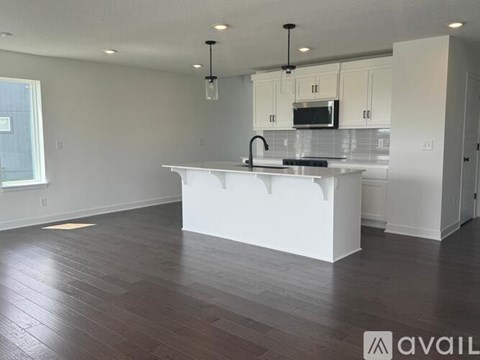 A kitchen with white cabinets and a white island.