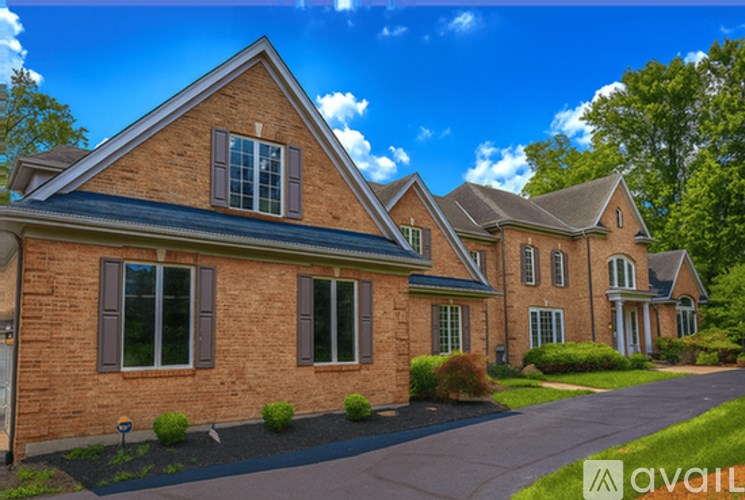 A large brick house with a driveway in front.