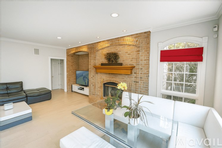 A living room with a brick fireplace and a glass table.