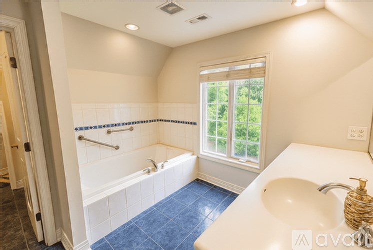A bathroom with a white tub and blue tiles.