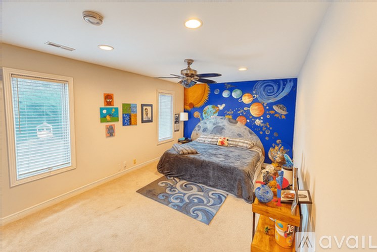 A bedroom with a bed, a ceiling fan, and a wall mural.