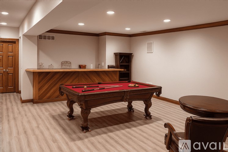 A pool table in a room with a wooden chair and a cabinet.