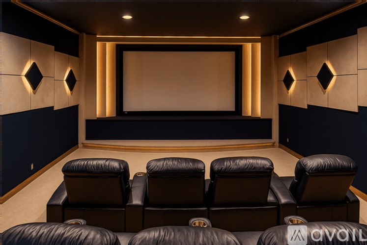 A home theater with black leather chairs and a large screen.