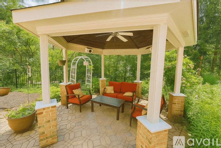A patio with a white pergola and a fan.