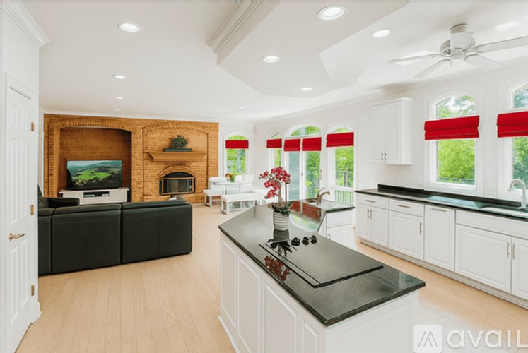 A modern kitchen with a black countertop and white cabinets.