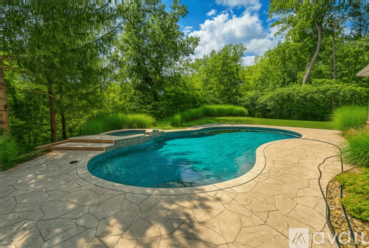 A swimming pool surrounded by a stone patio and greenery.