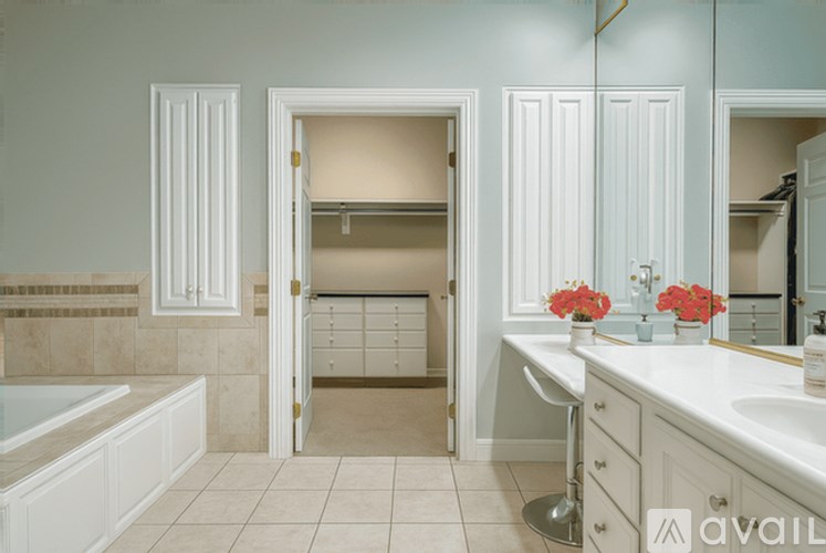 A bathroom with a tub, sink, and mirror.