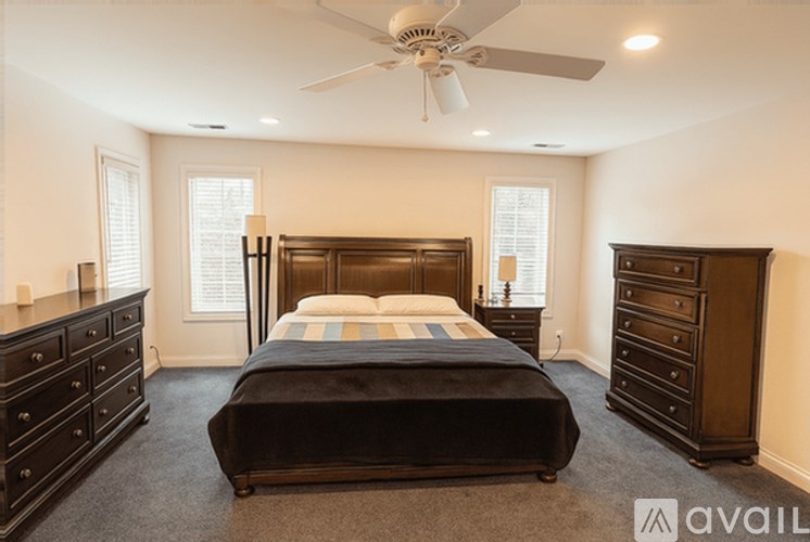 A bedroom with a large bed and a ceiling fan.