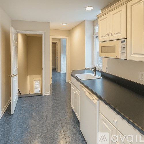 A kitchen with a sink, microwave, and cabinets.