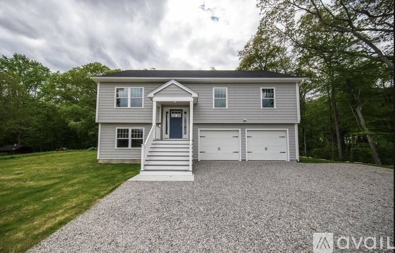 A house with a gravel driveway and two garages.