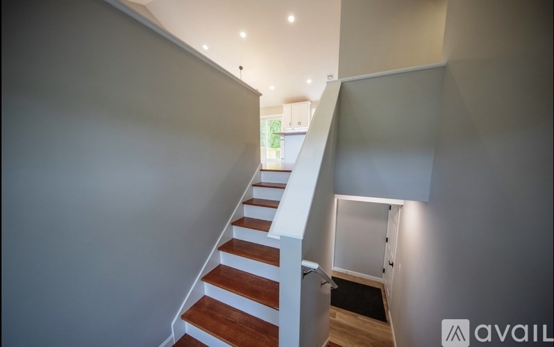 A staircase with wooden steps and a white railing.