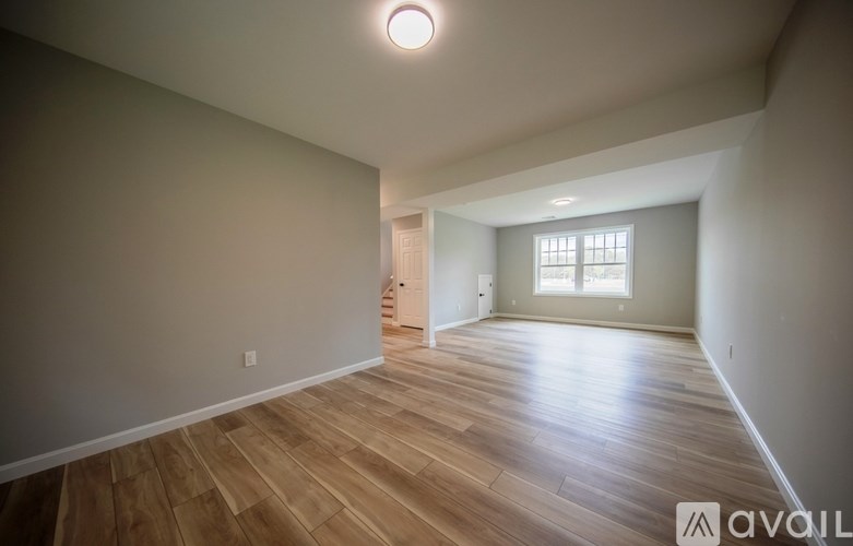 A room with wooden flooring and a window.