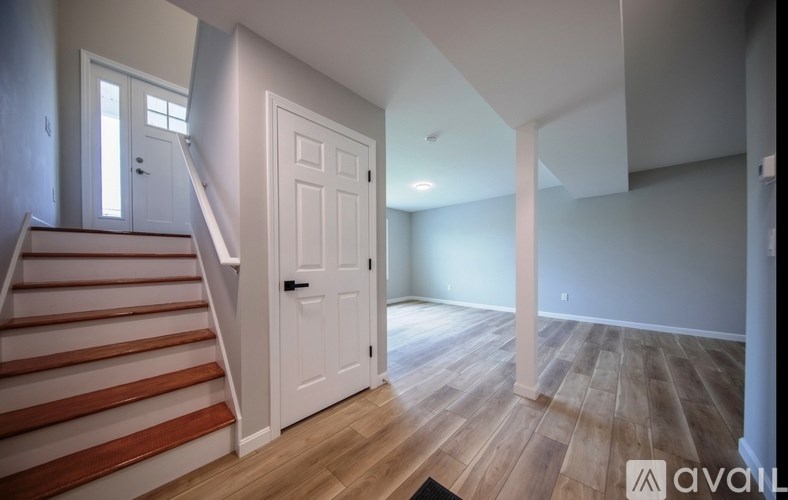 A room with wooden flooring and a white door.