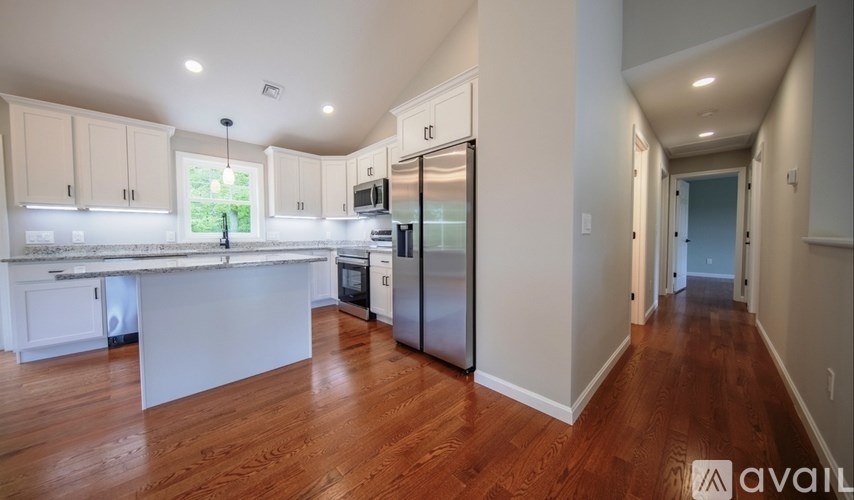 A kitchen with wooden floors and white cabinets is available for rent.