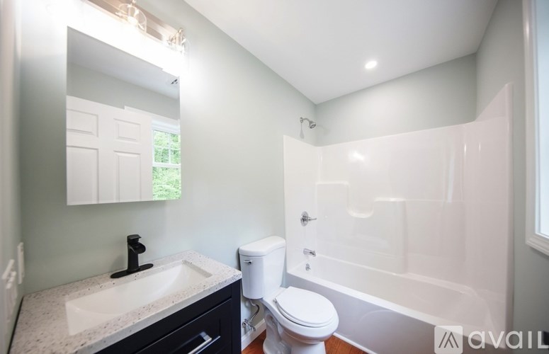 A bathroom with a toilet, sink, and bathtub.
