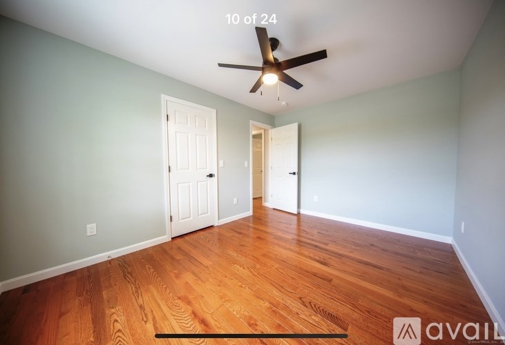 A room with wooden floors and a ceiling fan.