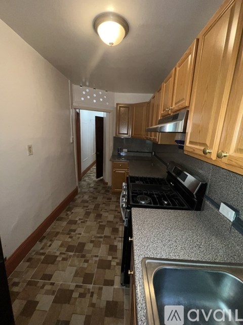 A kitchen with wooden cabinets and a checkered floor.